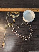 Full lot showing all five jewelry items next to ruler for scale