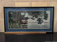 Full view of framed tapestry showing scene, mat, frame, and ruler for scale
