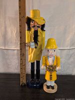 Both nutcrackers side by side beside ruler