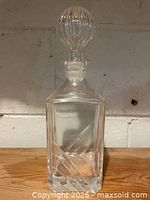 Full view of clear cut glass decanter with stopper attached