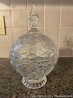 Full view of crystal covered compote showing footed base and lid