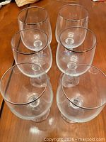 Six clear stemmed glasses top view showing silver rims