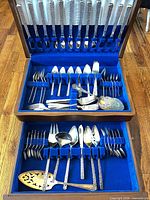 Full view of open flatware chest showing two tiers and assorted utensils