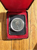 Coin obverse in capsule inside red case