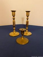 Front view showing all three brass candlesticks