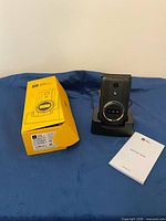 Phone on charging dock beside box and manual