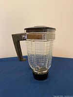 Side view of complete pitcher showing handle, lid, clamp band and bottom fitting