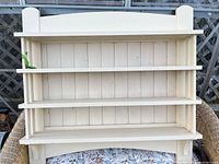 front view of cream painted pine wall shelf showing three shelves and top surface
