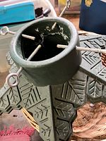 Overall view of green plastic Christmas tree stand showing four eye bolts and base design