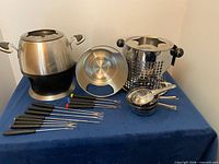 Overall view of both fondue pots, forks and accessories