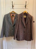 Both coats front view on hangers