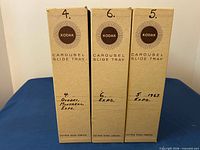 Front view of three Kodak Carousel Slide Tray boxes with handwritten labels
