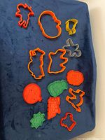 Group shot of all 14 holiday-themed cookie cutters displayed on blue surface