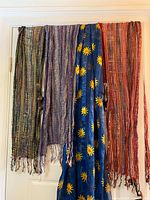 Four assorted lightweight scarves hanging to show color, pattern and fringe