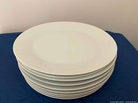 Stack of eight white dinner plates