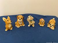 Front view of all five ceramic dog figurines
