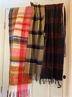 Three scarves draped showing full patterns and fringe