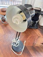 Lamp head showing white interior shade and installed spiral CFL bulb