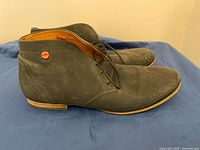 Left side view of both chukka boots showing distressed leather, outsole and logo