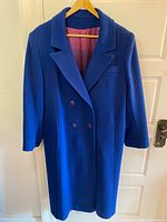 Front view of blue double-breasted wool coat with hanger