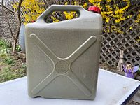 Front view showing X-reinforced panel, handle, red cap, embossed markings