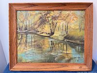Front view of framed oil painting showing landscape and oak frame