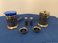 Front view of all six cobalt glass pieces in silver-plate holders