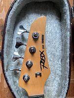 Headstock showing Yamaha RBX 350 logo and four chrome tuners inside case