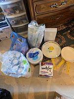 Lot overview with three GreenLife pans and assorted disposable tableware