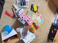 Multiple grooming and beauty items spread on carpet including hosiery, razors, combs, spray bottles, manicure kits