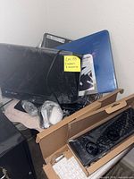 Pile showing HP and Emerson monitors, boxed Dell keyboard, accessories