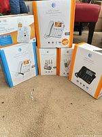 Five boxed AT&T phone systems arranged on floor