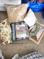 Overview of bedspread in packaging, two quilts and two pillows on floor