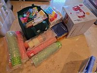 Group shot of mixer box, paper cups, bagged party supplies and green tote