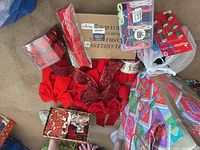 Overview of lot showing ornaments, bows, ribbon, flameless candle box, garland, gift tag box