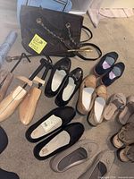 Overview: multiple pairs of women’s shoes, dark brown tote, wooden shoe trees, blue umbrella