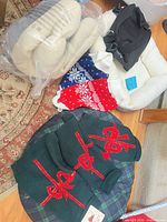 Group shot showing knit sweaters, sherpa bed, packaged bed cushion, black carrier