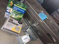 Toolbox with weatherstripping packages and metal hinges shown