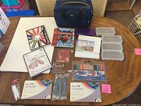Entire lot showing pastels, pencils, sketchbooks, canvas panels, storage boxes and carry bag
