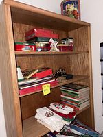 Full shelf view with tins, figurine, teapot, books and towels