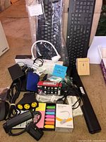 Overview of all items including keyboards, mice, hard drive, lamp, phone box, power adapters, cables, power strip, sticky flags