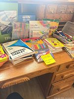 Desk top view showing majority of supplies including pastels, markers, paints and writing tablet