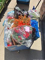 Blue bin filled with bagged artificial flowers in various colors
