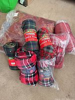 Group shot showing all rolled fleece throws, velvet touch throws in plastic wrap, and large jacquard blanket bagged