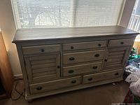 Front view showing full dresser, drawer and cabinet arrangement, finish, hardware, feet