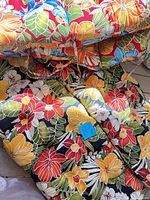 Stack of four floral tropical tufted cushions showing pattern, sizes and tie straps