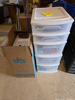 Boxed Sun Pure water filtration system beside four-drawer clear plastic cabinet