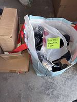 Bag containing assorted black bun feet, casters and hardware