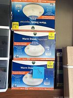 Stack of three sealed Vicks Warm Steam Vaporizer retail boxes showing product image and specifications