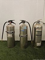 Front view of all three extinguishers standing upright